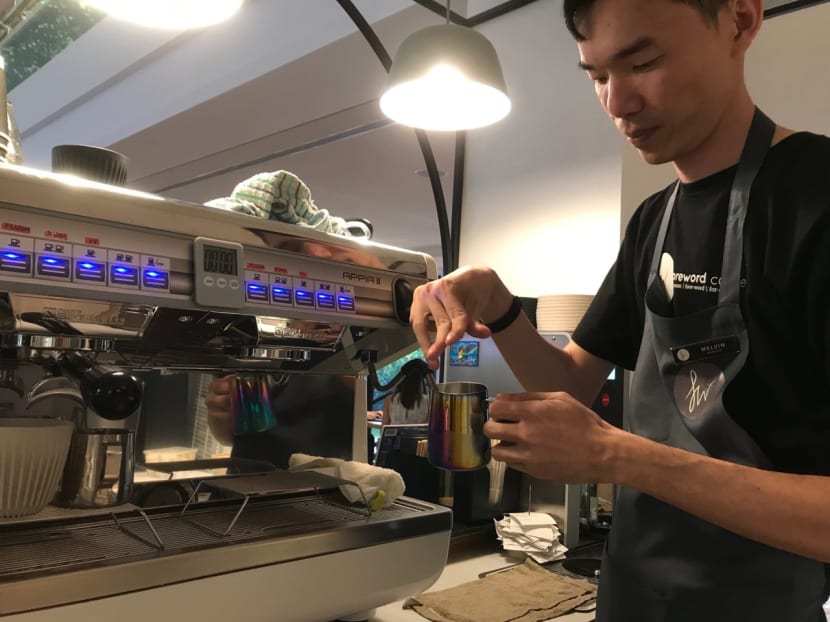 Mr Melvin Sii, an assistant outlet manager at Foreword Coffee’s Dhoby Ghaut outlet, using an automatic milk frother.