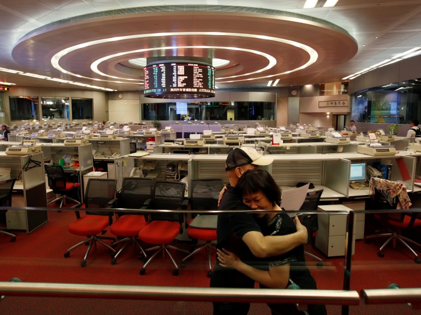 Catherine Cheung, a floor trader since 1994, is hugged by her colleague before leaving the trading hall of the Hong Kong Exchanges in Hong Kong. Photo: Reuters