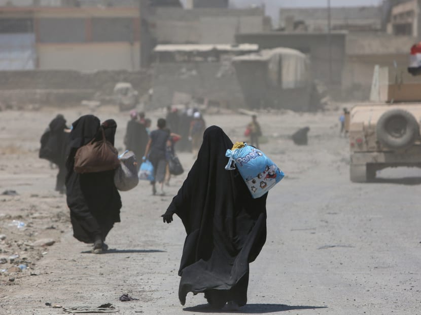 Displaced Iraqi civilians are escorted out of Mosul's Old City by Iraqi security forces during fighting between Iraqi security forces and Islamic State militants in Mosul, Iraq. Photo: Reuters