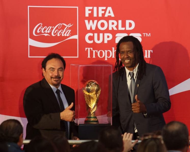 Mexican fans enjoy a brief respite from violence as they gaze at World Cup trophy
