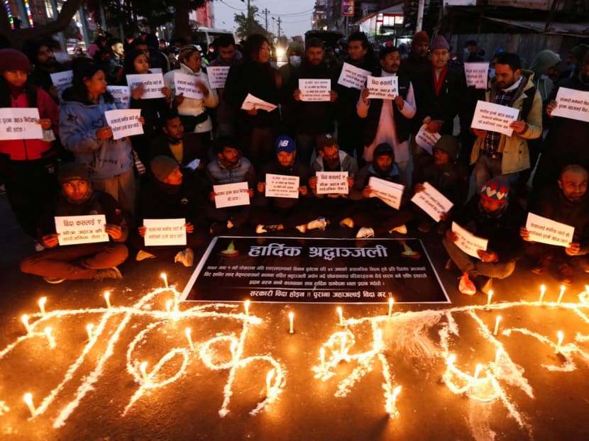 People hold placards as they take part in a condolence and protest meeting following the plane crash of a Yeti Airlines operated aircraft, in Pokhara on Jan 15, 2023, in Kathmandu, Nepal.