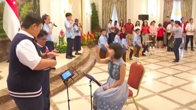 特需学校学生在国庆敬礼仪式上演唱多种语言的爱国歌曲