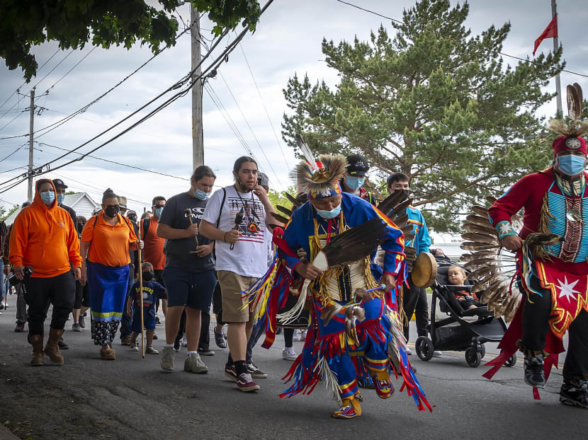 Members of the community of the Kahnawake Mohawk Territory, Quebec march through the town to commemorate the news that a mass grave of 215 Indigenous children were found at the Kamloops Residential School in British Columbia, Canada on May 30, 2021.