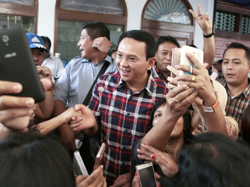 Mr Purnama being mobbed by supporters during an event in Jakarta yesterday. He thanked the police for dealing with the blasphemy case in a professional manner and urged supporters to vote for him in the gubernatorial elections. Photo: AP