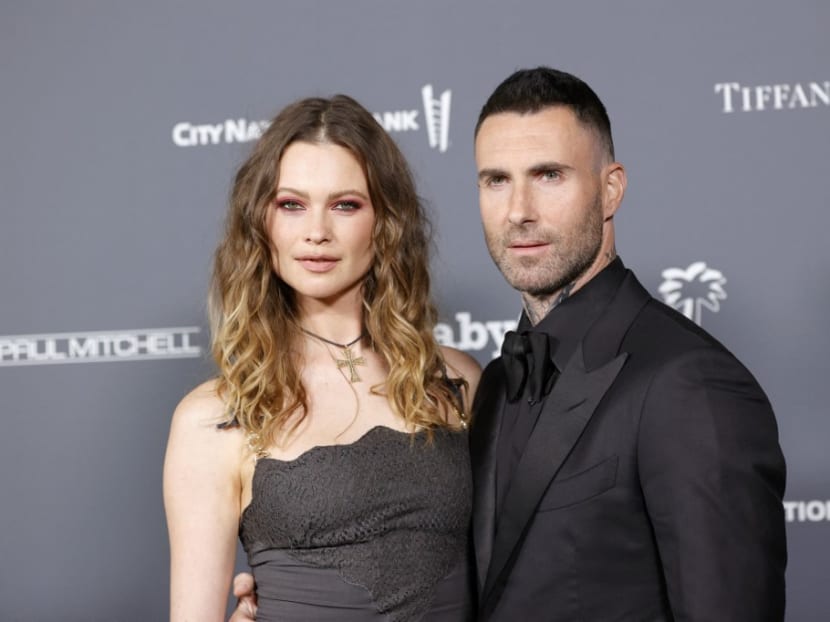 Singer Adam Levine is seen here with his wife, Victoria's Secret model Behati Prinsloo, at a red carpet event in November 2021. 