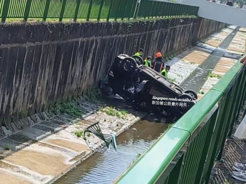 A photo posted on Facebook group Singapore road accidents.com showed an overturned black car in the canal. A photo posted on Facebook group Singapore road accidents.com showed an overturned black car in the canal.