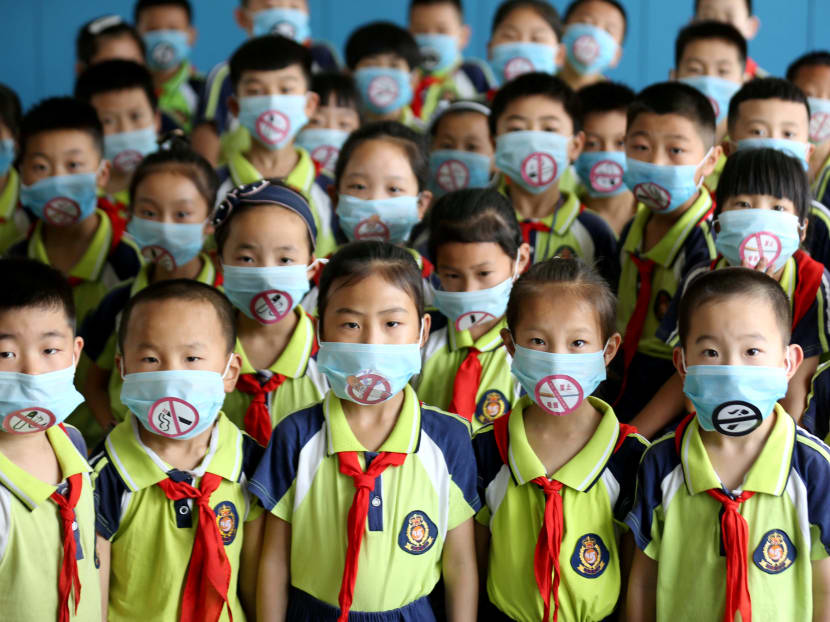 Primary school students wear masks with “No Smoking” sign during an event to promote the World No Tobacco Day on May 31, in Shandong province.
