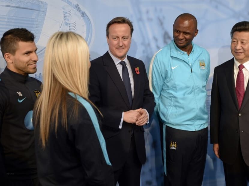 Chinese President Xi Jinping (right), Manchester City’s Head of the Elite Development Squad Patrick Vieira (second from right), then British Prime Minister David Cameron (centre), and Manchester City's Argentinian striker Sergio Aguero (left) listening to a staff member during a visit to the City Football Academy in Manchester in 2015. Photo: AFP