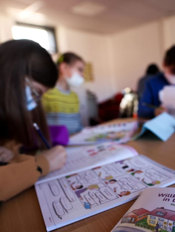 A book called 'Welcome to Germany' is pictured as refugee children, who fled following Russia's invasion of Ukraine, attend a preparation course in a school in Dusseldorf, Germany. 