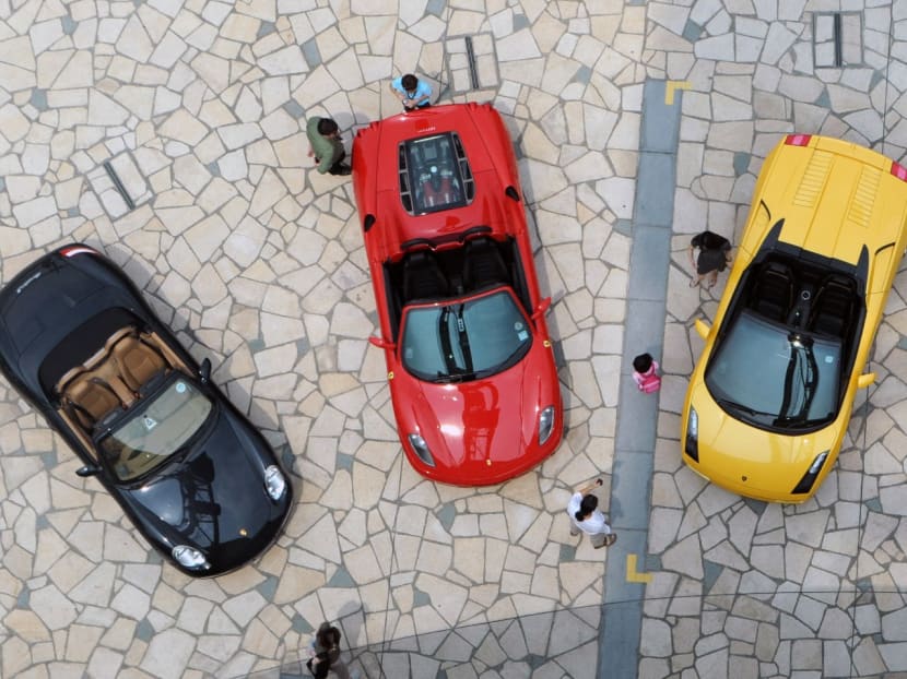 A file picture of people looking at Porsche, Ferrari and Lamborghini cars near the Singapore Flyer during the Formula One motorsports race in Singapore. A file picture of people looking at Porsche, Ferrari and Lamborghini cars near the Singapore Flyer during the Formula One motorsports race in Singapore.