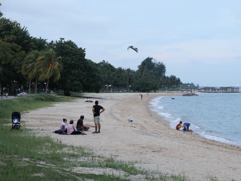 People are seen at the beach in East Coast Park.