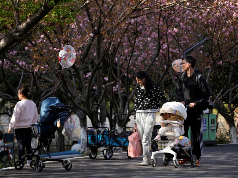 A parents pushes a stroller with a baby in a park in Shanghai, China on April 2, 2023. 