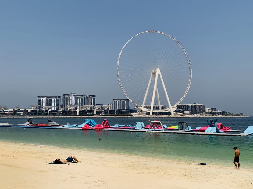 A man sunbathes along the Marina beach near the Ain Dubai Ferris wheel in the Gulf emirate of Dubai on July 7, 2020.
