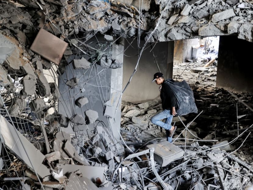 A Palestinian youth looks for salvageable items that can be sold, in the ruins of a building destroyed during the recent Israeli bombings, in Gaza City on May 27, 2021.