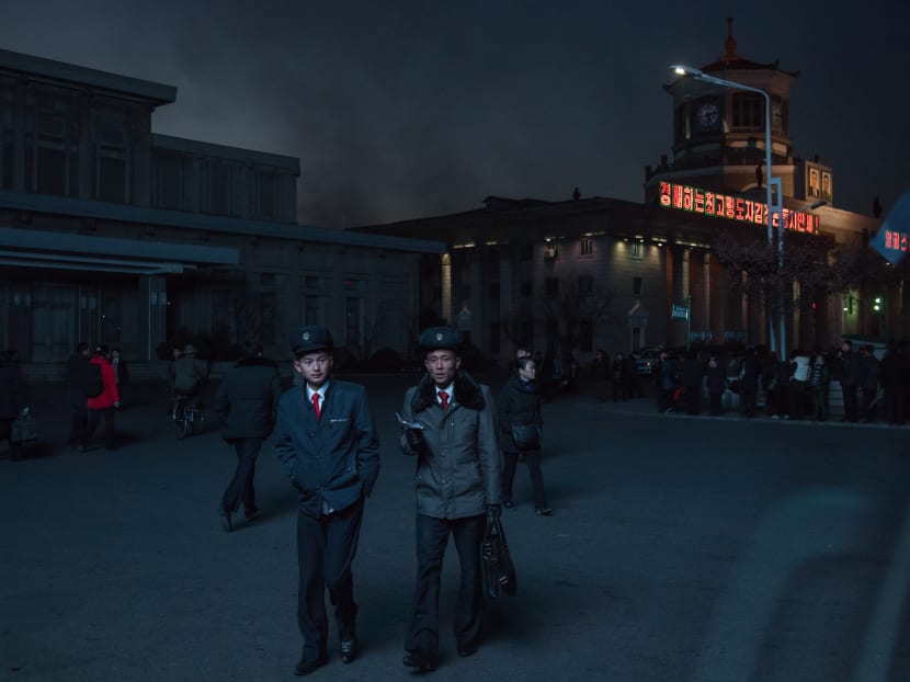 North Korean students illuminated by a public television screen walk past the central station in Pyongyang. Analysts say United States President Donald Trump’s re-designation of North Korea as a state sponsor of terrorism may have dashed cautious hopes in the region that talks and diplomacy would replace escalating tensions and bellicose threats. Photo: AFP