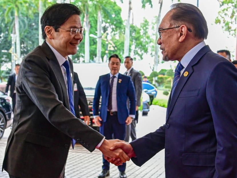 This handout photo taken and released by Malaysia's Department of Information on June 12, 2024 shows Malaysia's Prime Minister Anwar Ibrahim (right) and his Singapore counterpart Lawrence Wong shaking hands ahead of their meeting in Putrajaya.