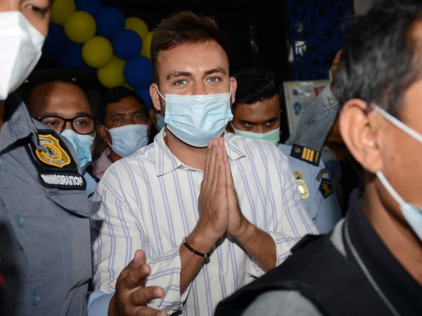 This picture taken on Jan 24, 2021 shows Russian national Sergey Kosenko (centre) being escort from the imigration office to Ngurah Rai Airport in Jimbaran, on Indonesia resort island of Bali.