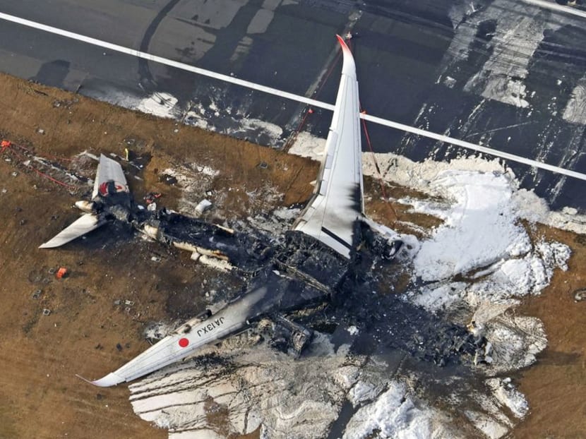 An aerial view shows burnt Japan Airlines' Airbus A350 plane after a collision with a Japan Coast Guard aircraft at Haneda International Airport in Tokyo, Japan.
