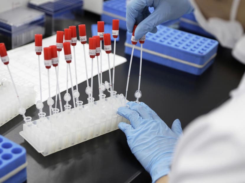A technician handles a DNA sample at a Genesis Healthcare laboratory in Tokyo, Japan.