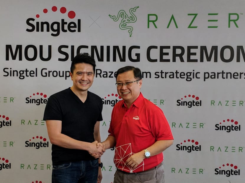 (Left) Razer CEO Tan Min-Liang shakes hands with Singtel’s International Group CEO Arthur Lang after the announcement of a strategic partnership in e-payments, e-sports and telco services on Wednesday, May 2, 2018.