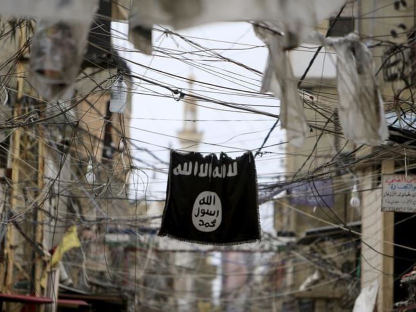 An Islamic State in Iraq and Syria (Isis) flag hangs amid electrical wires. A 34-year-old man has become the second Singaporean to be charged with terrorism financing.