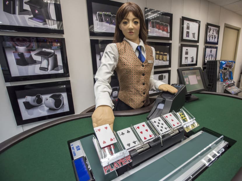 A robotic baccarat dealer deals a card during a demonstration at the headquarters of Paradise Entertainment Ltd., in Macau, China. Photo: Bloomberg