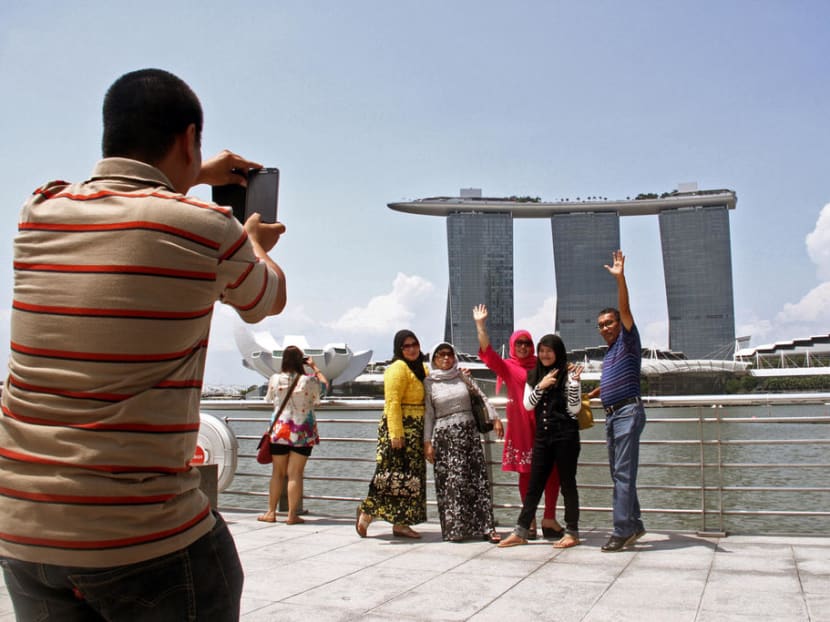 Tourists posing for photographs at Marina Bay.