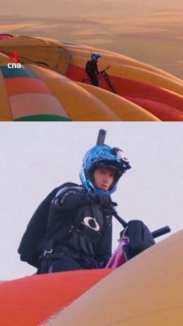 Austrian cyclist becomes first person to ride on top of hot air balloon