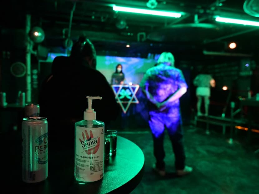 Hand sanitiser is seen on a table as guests enjoy music during a farewell party of the underground music club MWG in the Hongdae nightlife district of Seoul as the club shuts down due to the Covid-19 pandemic.