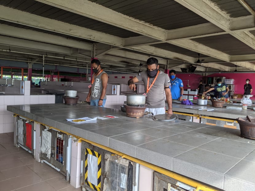 Dormitory residents of Changi Lodge 2 cooking at the communal kitchen.