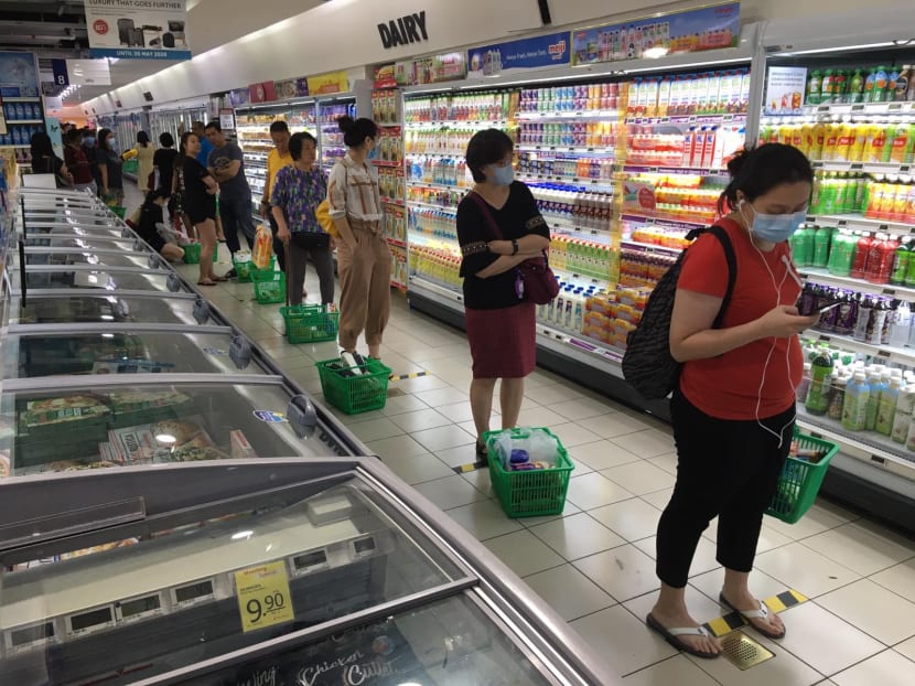 Shoppers queue up at the NTUC FairPrice outlet at Northpoint City shopping mall in Yishun.