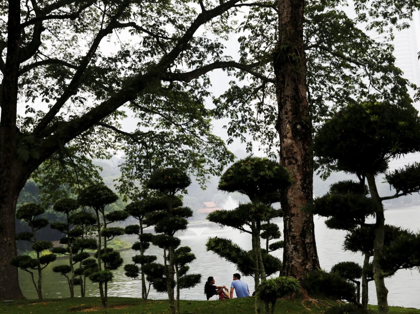 A couple talk in the park on a hazy day in Kuala Lumpur, Malaysia, October 18, 2015. Photo Reuters