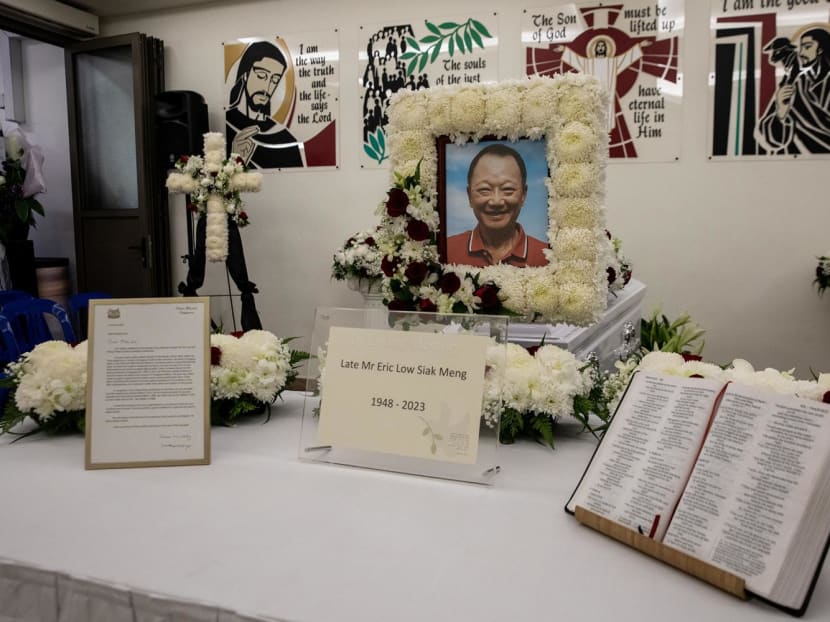 A letter (left) from Prime Minister Lee Hsien Loong and a bible (right) being displayed in front of Eric Low's portrait and casket at his wake held at the Church of the Holy Spirit on Jan 4, 2022.