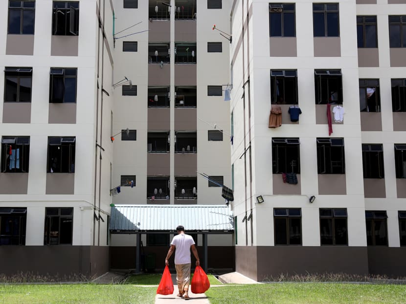 A foreign worker in Tampines Dormitory returns to his room with the catered lunch for his roommates on April 21, 2020. Workers in each room take turns to collect three meals a day from the distribution point and return to their rooms to eat.