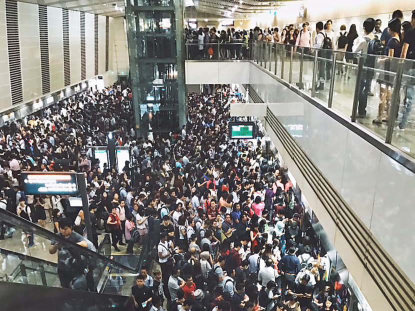The crowd at Bishan station at about 8.45am yesterday. An interference caused a loss of signal between trains and stations, forcing the trains to come to a halt. SMRT staff had to make their way to the stalled unmanned trains to drive them to station platforms. Photo: n1veda/twitter