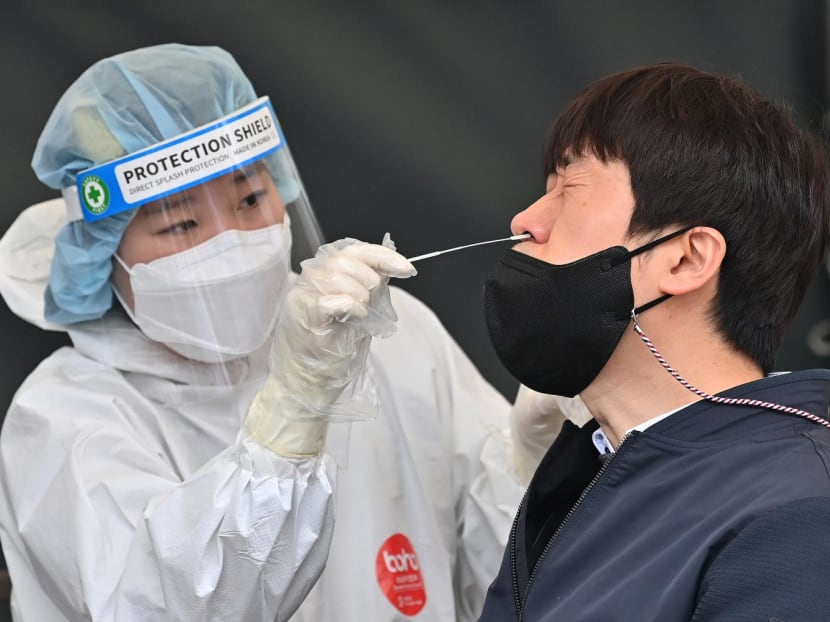 A medical worker takes a nasal swab sample from a man at a Covid-19 coronavirus testing centre in Seoul on March 17, 2022. A medical worker takes a nasal swab sample from a man at a Covid-19 coronavirus testing centre in Seoul on March 17, 2022.