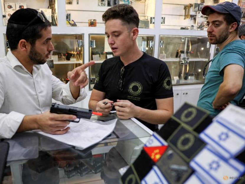 A customer speaks to a member of staff at a gun shop at the Caliber 3 shooting range in Gush Etzion, an Israeli settlement in the Israeli-occupied West Bank, on Oct 25, 2023. 