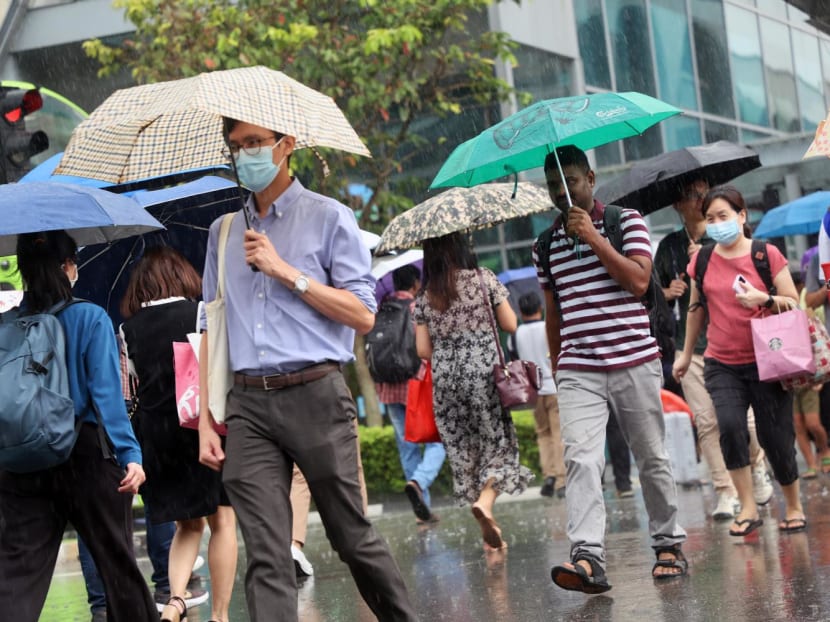 Pedestrians cross a road in the rain in Jurong East on Aug 16, 2023. Pedestrians cross a road in the rain in Jurong East on Aug 16, 2023.