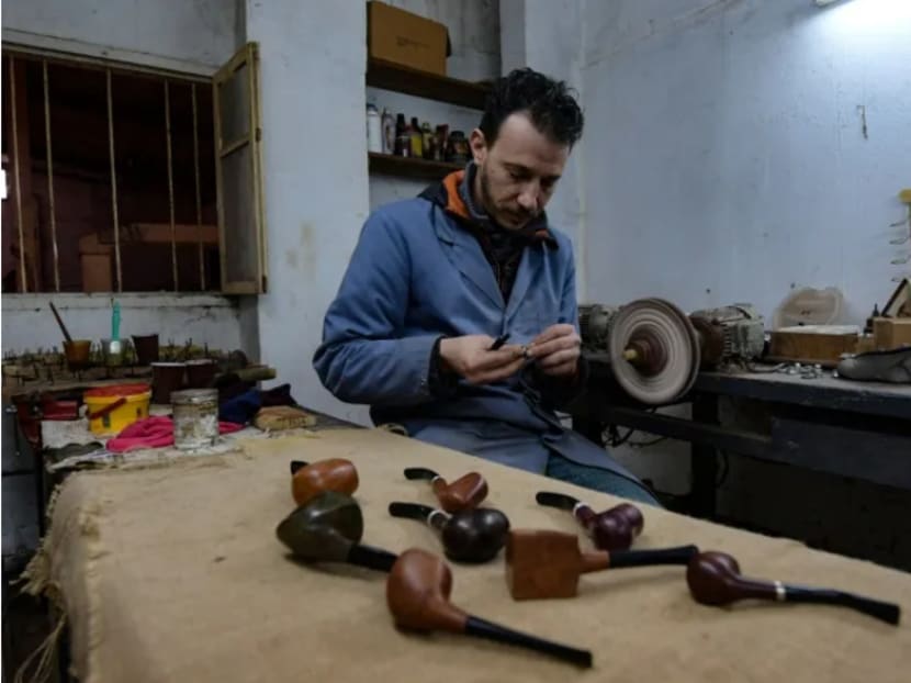Mr Anis Bouchnak works on a briar wood pipe at his workshop in the northwestern Tunisian coastal town of Tabarka, on January 28, 2021. Mr Bouchnak, 37, who in 2011 took over the family business started by his grandfather, is the only craftsman in Tunisia, and one of the few in the region, to continue to make pipes by hand.