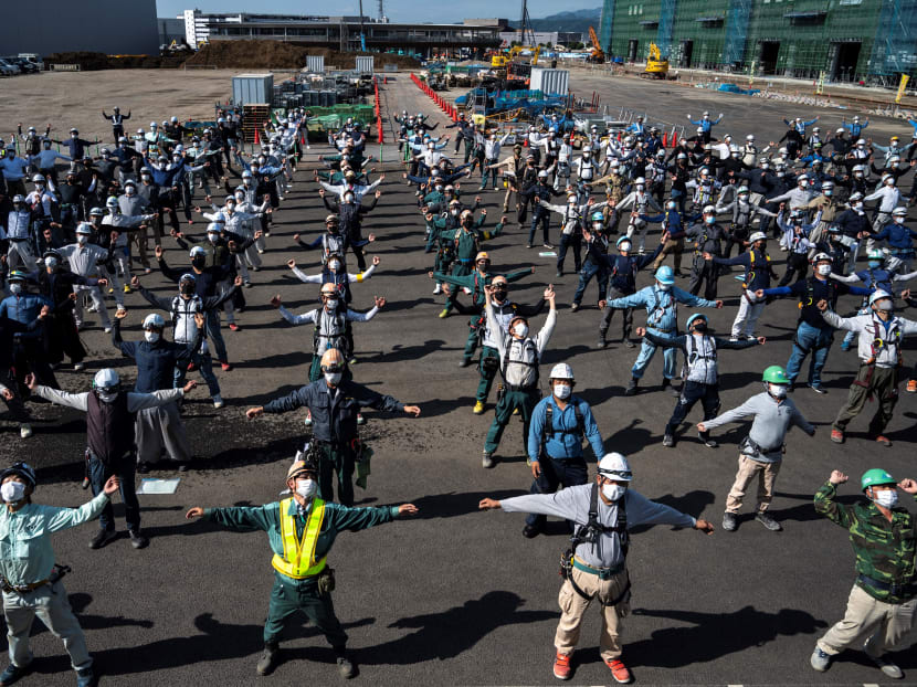 Workers from Tokyu Construction Co take part in a morning 'radio taiso' exercise — a daily workout performed in unison by millions of Japanese every day — before starting their shift at a construction site in Sagamihara, Kanagawa prefecture, Japan on June 18, 2021. Workers from Tokyu Construction Co take part in a morning 'radio taiso' exercise — a daily workout performed in unison by millions of Japanese every day — before starting their shift at a construction site in Sagamihara, Kanagawa prefecture, Japan on June 18, 2021.