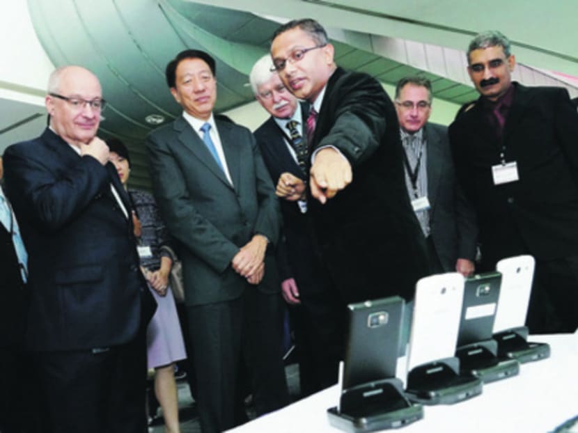 LiveLabs Director, SMU Assoc Prof Archan Misra explaining to Deputy Prime Minister Teo Chee Hean (second from left) how data would be collected from the mobile devices. PHOTO COURTESY SMU