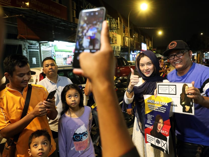 Ms Nur Fathiah Syazwana, an independent candidate contesting the Batu parliamentary seat in Malaysia’s 15th General Election, pose for photos with customers at a night market in Batu on Nov 16, 2022. Ms Nur Fathiah Syazwana, an independent candidate contesting the Batu parliamentary seat in Malaysia’s 15th General Election, pose for photos with customers at a night market in Batu on Nov 16, 2022.