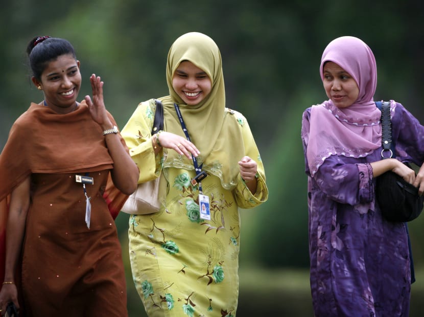 Malaysian young workers share a light moment as they leave office after work in Putrajaya. Many young Malaysian adults are selling unit trust and insurance schemes in order to earn a living. Photo: Reuters