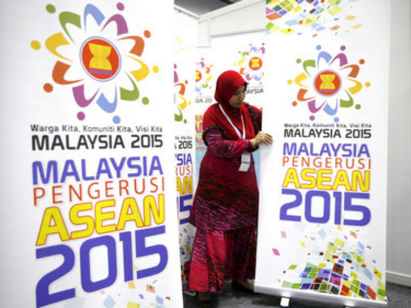 A woman setting up banners yesterday for the 26th ASEAN Summit at the Kuala Lumpur Convention Centre. ASEAN could replace China as the world’s leading manufacturing centre in the next 10 to 15 years. Photo: REUTERS