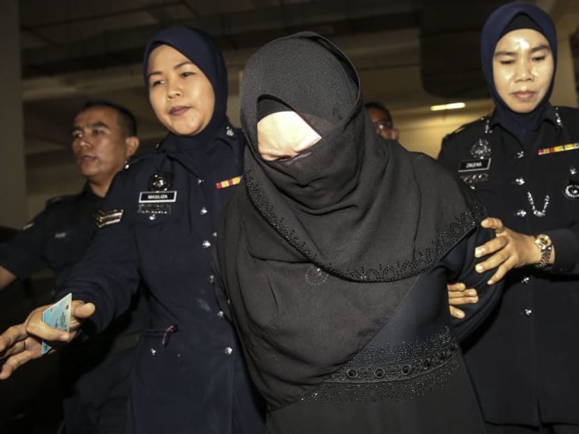 Datin Rozita Mohamad Ali is escorted by police at the Shah Alam High Court on Thursday (March 29). Photo: Malay Mail Online