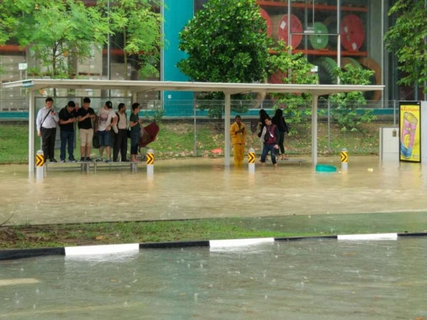 Commuters waiting for their respective buses are seen standing on benches to avoid the flood waters on Jan 8, 2018. Photo: Social media Commuters waiting for their respective buses are seen standing on benches to avoid the flood waters on Jan 8, 2018. Photo: Social media