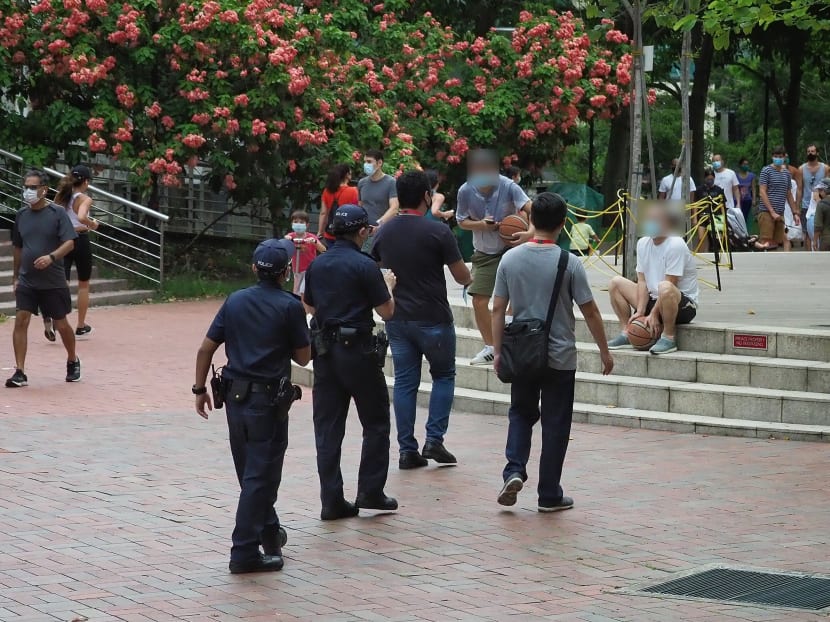 Police and enforcement officers approaching people sitting on steps at Robertson Quay on May 17, 2020. Police and enforcement officers approaching people sitting on steps at Robertson Quay on May 17, 2020.