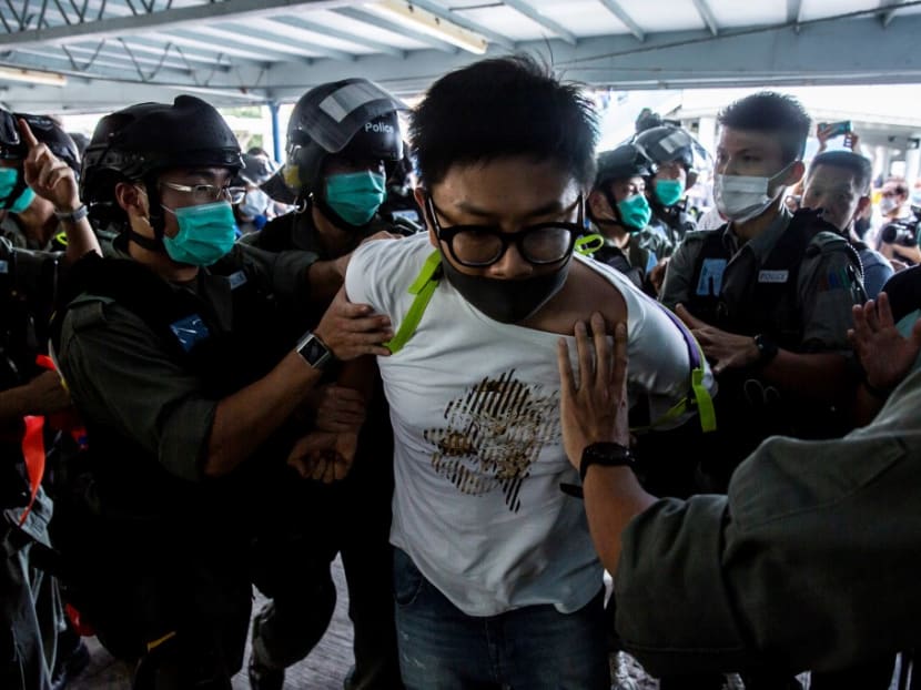 Police officers arrest a demonstrator during a protest in Hong Kong on May 10, 2020.
