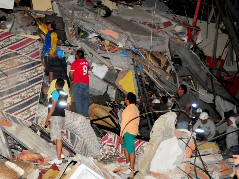 People stand on the debris of a building after an earthquake struck off the Pacific coast in Manta, Ecuador, April 16, 2016. Photo: Reuters