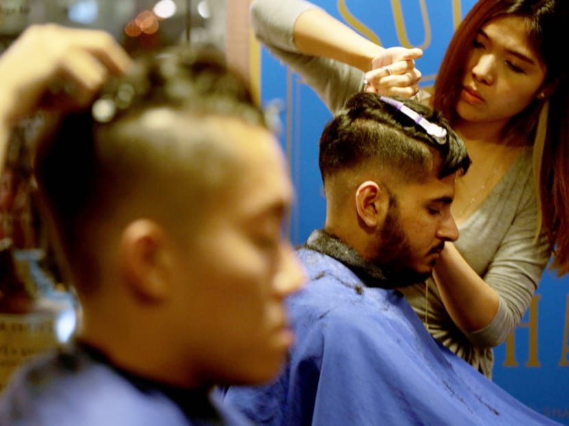 Customers getting haircuts in the style of Paul Pogba, Aaron Ramsey and Sergio Ramos. Photo: Jason Quah
